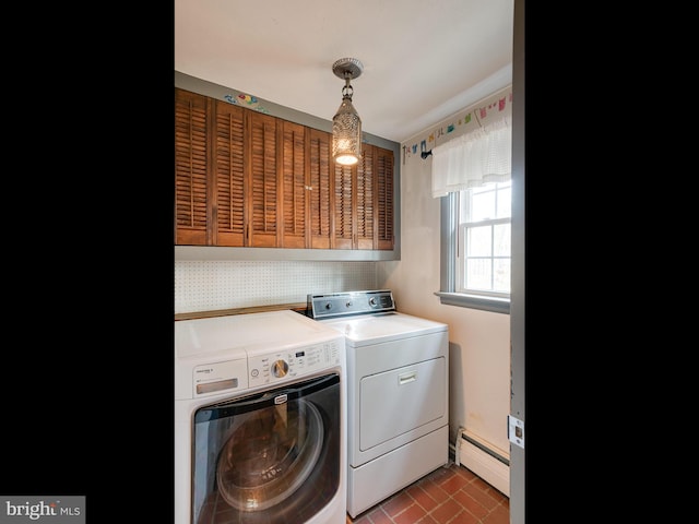 clothes washing area with a baseboard heating unit, washing machine and dryer, brick floor, baseboards, and laundry area