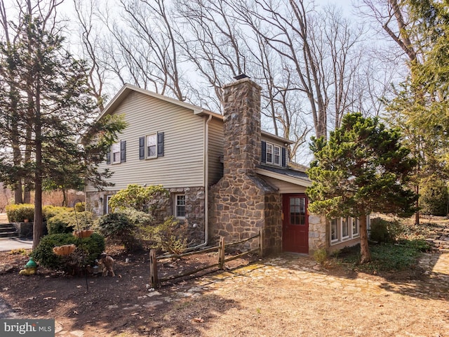 view of front of property featuring stone siding and a chimney
