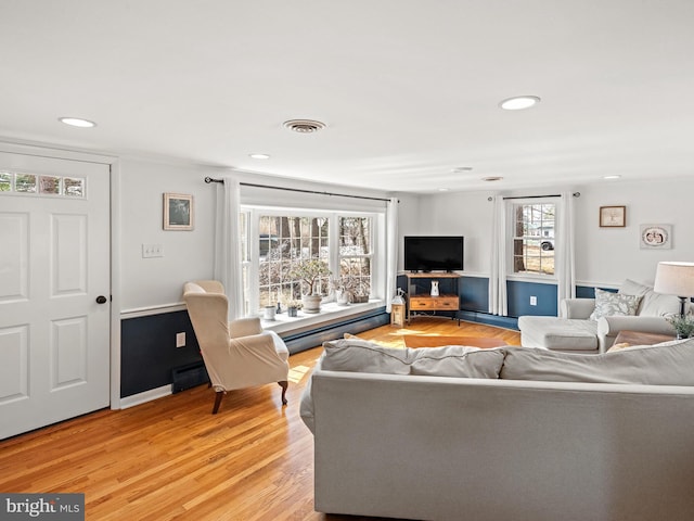 living area featuring recessed lighting, light wood-style floors, and visible vents