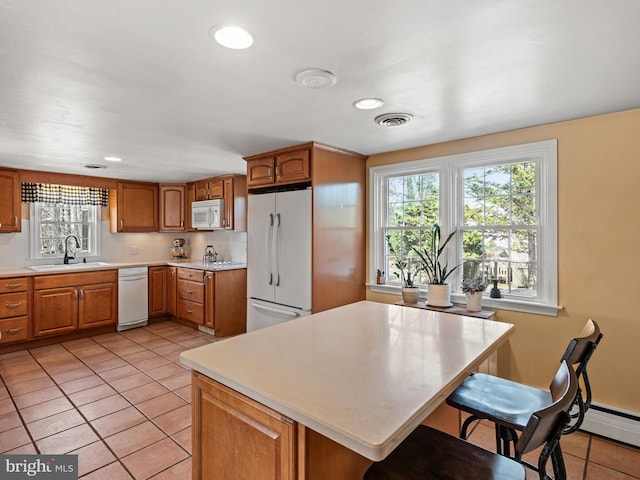 kitchen with white appliances, light countertops, visible vents, and backsplash