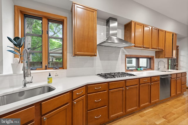4544 30th St NW, Washington, DC 20008 - kitchen featuring wall chimney range hood, stainless steel appliances, brown cabinets, and a sink