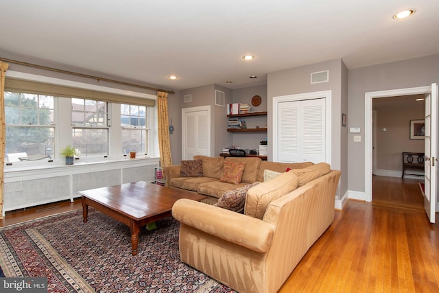 living area featuring light wood finished floors, baseboards, and recessed lighting