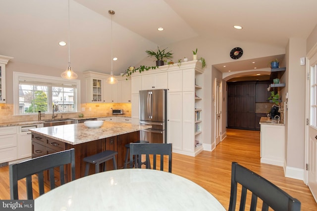 kitchen with freestanding refrigerator, open shelves, a sink, white cabinets, and high vaulted ceiling