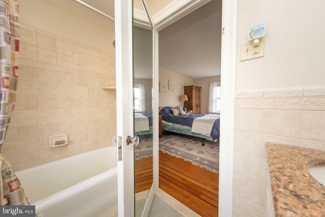 ensuite bathroom featuring shower / tub combo with curtain