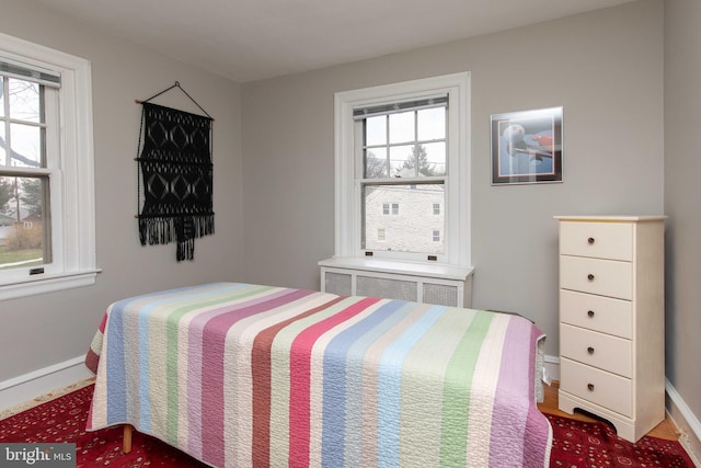 bedroom featuring radiator heating unit and baseboards