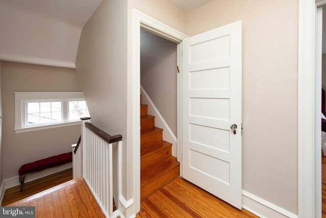 stairway with wood finished floors and baseboards
