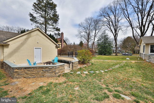 view of grassy yard with an outdoor fire pit