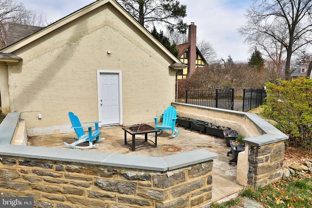 view of patio / terrace with an outdoor fire pit and fence