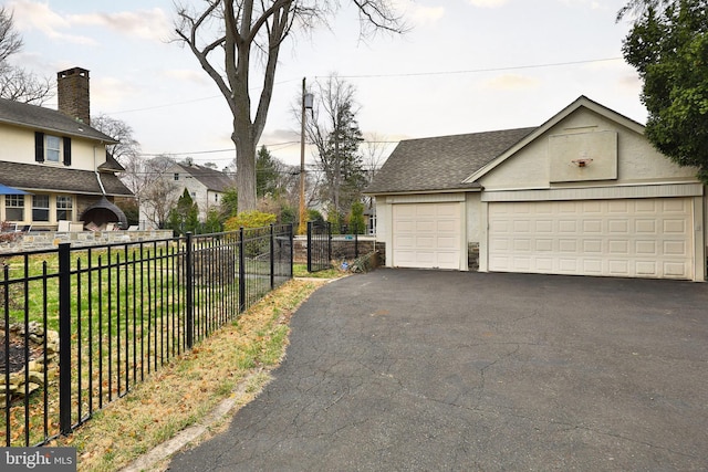 detached garage featuring fence