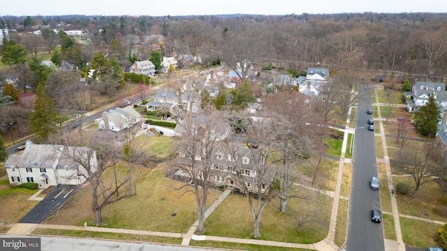 aerial view of property's location with nearby suburban area and a heavily wooded area