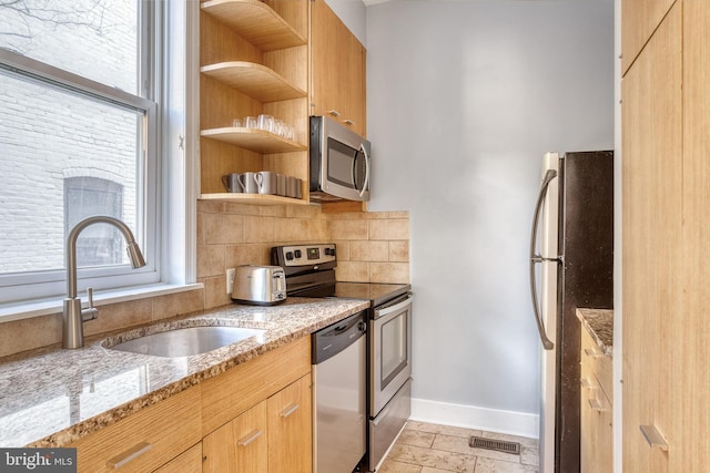 kitchen with a sink, visible vents, appliances with stainless steel finishes, and plenty of natural light