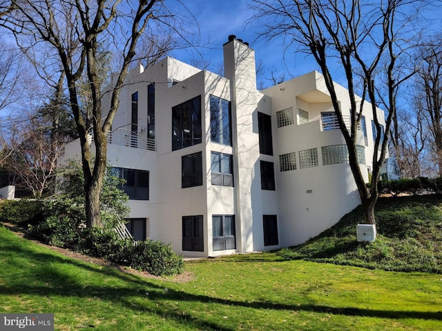 910 Pennwood Cir, Lancaster, PA 17601 - rear view of house with stucco siding, a chimney, and a lawn