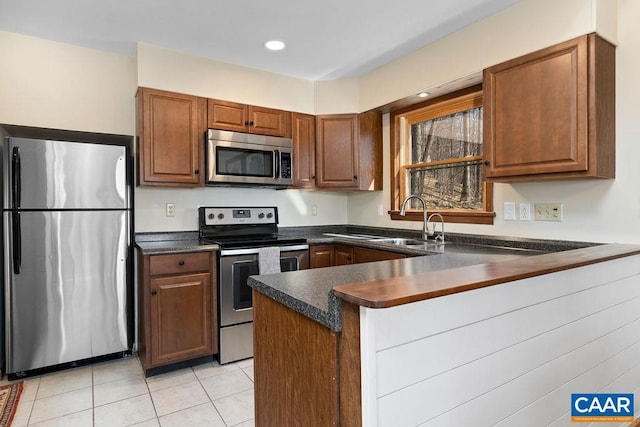 145 Firtree Dr, Wintergreen Resort, VA 22967 - kitchen with dark countertops, light tile patterned floors, a peninsula, stainless steel appliances, and a sink