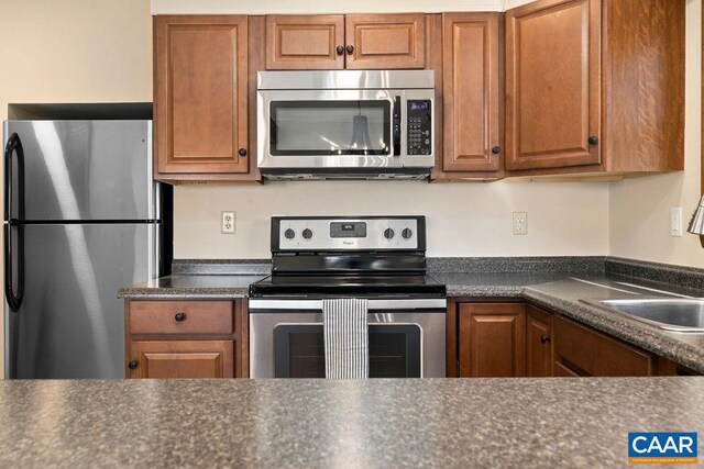 145 Firtree Dr, Wintergreen Resort, VA 22967 - kitchen with dark countertops, appliances with stainless steel finishes, brown cabinetry, and a sink