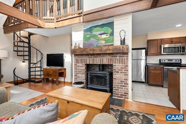 145 Firtree Dr, Wintergreen Resort, VA 22967 - living area with stairway, baseboards, light wood-style flooring, and a wood stove