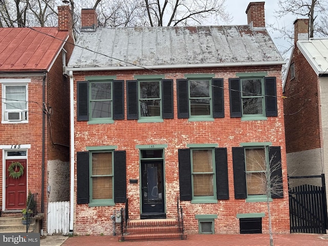 view of front of property with a chimney and brick siding