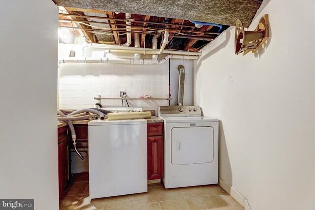 laundry area featuring cabinet space, light tile patterned floors, and separate washer and dryer
