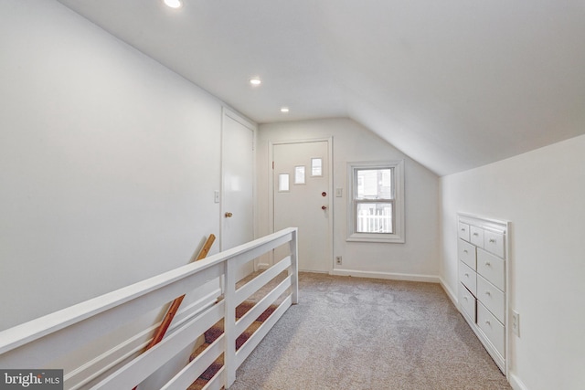 interior space featuring light carpet, an upstairs landing, recessed lighting, baseboards, and vaulted ceiling