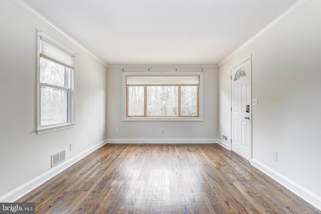 interior space featuring visible vents, baseboards, wood finished floors, and ornamental molding