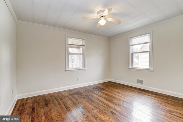 unfurnished room with visible vents, wood finished floors, and ornamental molding