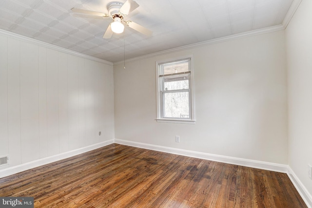 spare room featuring dark wood-style floors, baseboards, crown molding, and ceiling fan