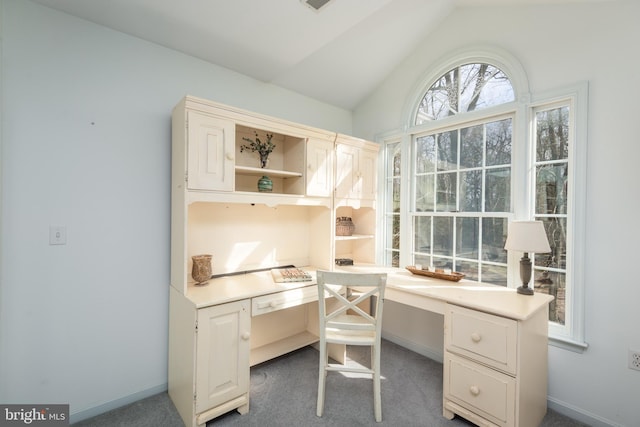 carpeted office featuring baseboards, lofted ceiling, and built in study area