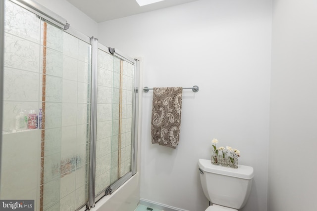 full bath with toilet and shower / bath combination with glass door