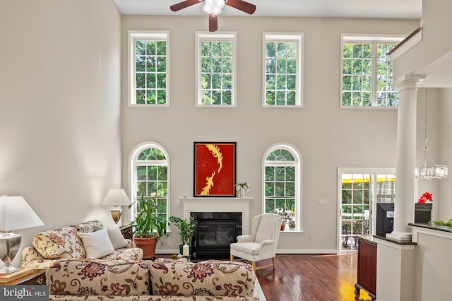8725 Warm Waves Way Unit 10, Columbia, MD 21045 - living area with a fireplace with flush hearth, a towering ceiling, a ceiling fan, dark wood-style floors, and healthy amount of natural light