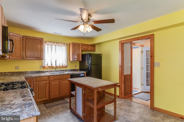 kitchen with visible vents, baseboards, ceiling fan, a sink, and black appliances