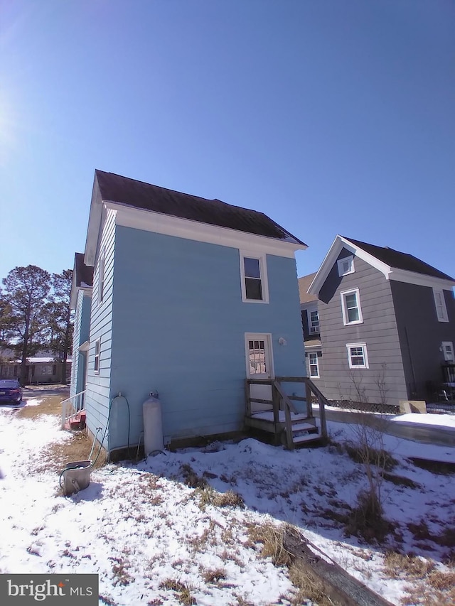 view of snow covered rear of property