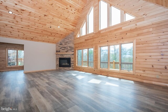unfurnished living room featuring high vaulted ceiling, a stone fireplace, wood walls, wooden ceiling, and baseboards
