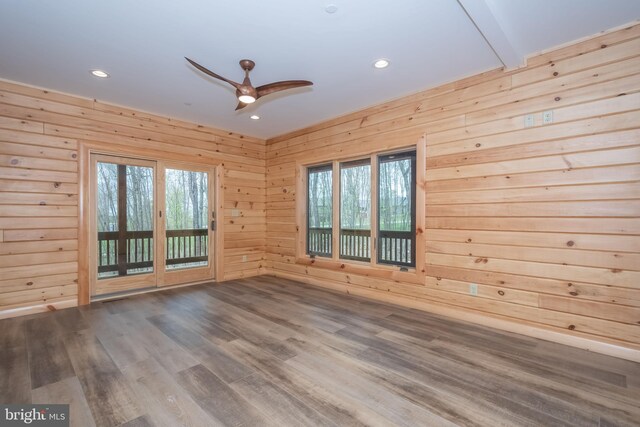 empty room featuring ceiling fan, recessed lighting, wooden walls, and wood finished floors