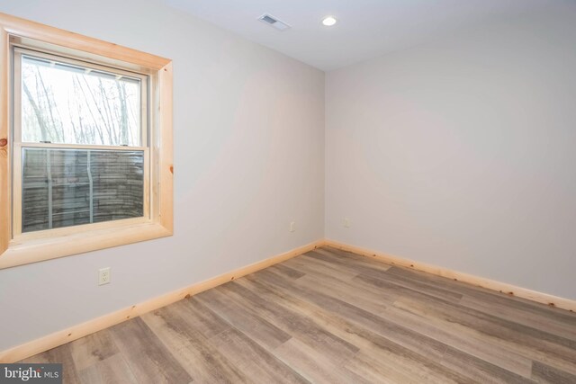 spare room featuring baseboards, wood finished floors, and recessed lighting