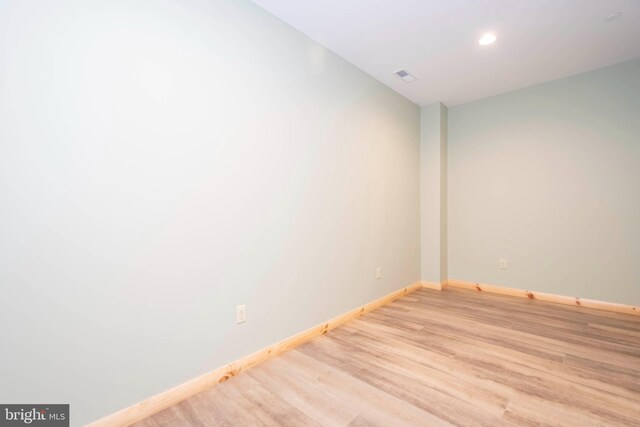 unfurnished room featuring light wood finished floors, baseboards, and recessed lighting