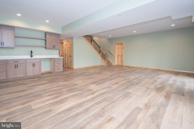 kitchen with open shelves, light wood finished floors, recessed lighting, open floor plan, and baseboards