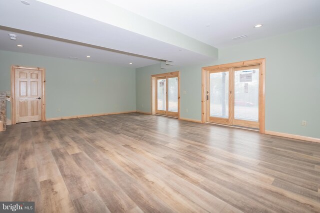 unfurnished living room featuring wood finished floors, baseboards, and recessed lighting