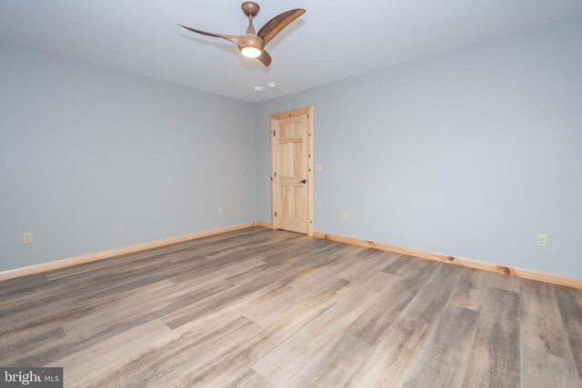 unfurnished room with ceiling fan, baseboards, and wood finished floors