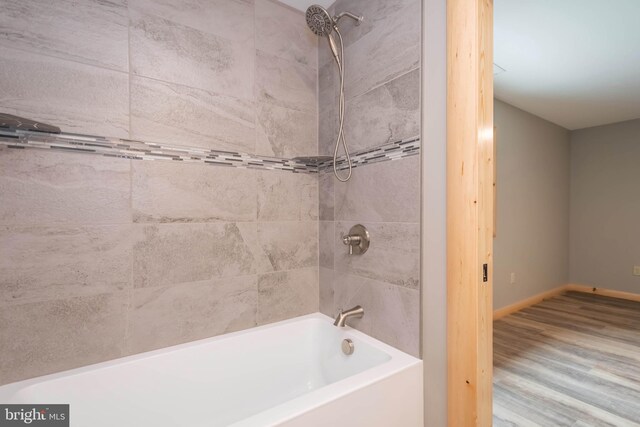 full bathroom featuring shower / bathtub combination, baseboards, and wood finished floors