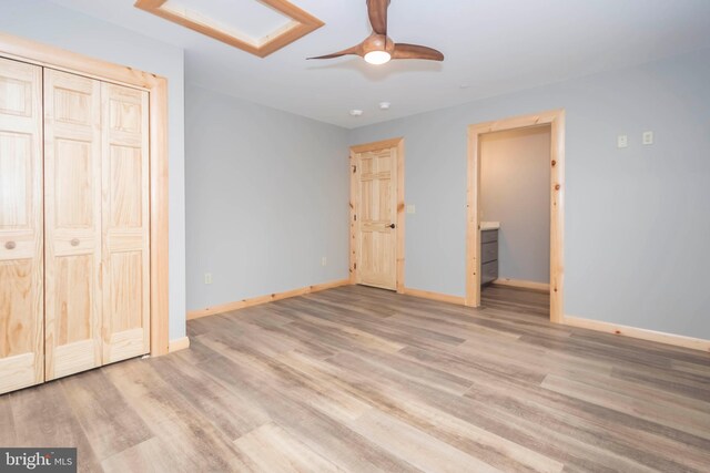 unfurnished bedroom featuring baseboards, wood finished floors, and ceiling fan