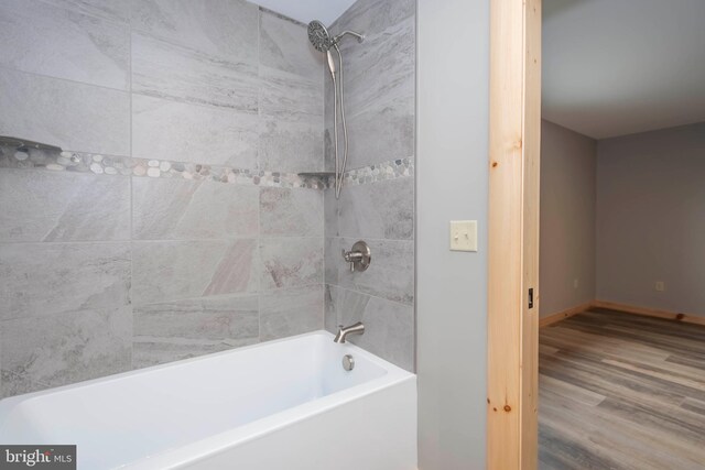 full bath featuring wood finished floors and  shower combination