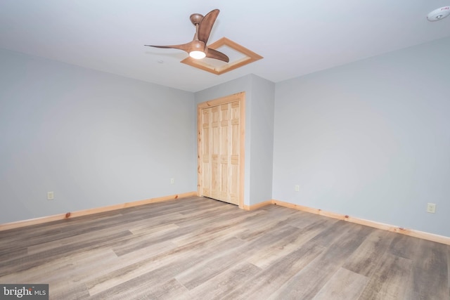 spare room featuring wood finished floors, baseboards, ceiling fan, and a smoke detector
