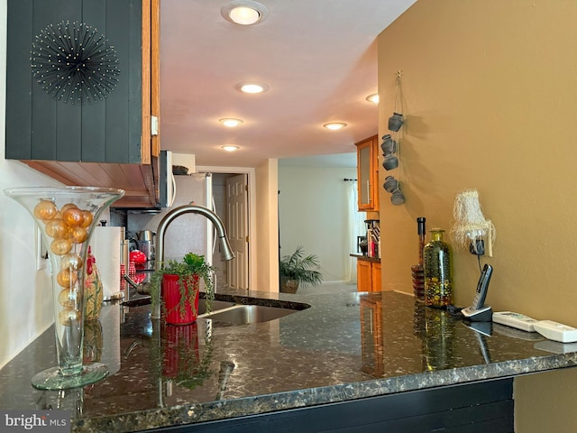 22 Chilmark Ct, Bear, DE 19701 - kitchen with glass insert cabinets, dark stone counters, recessed lighting, a peninsula, and a sink