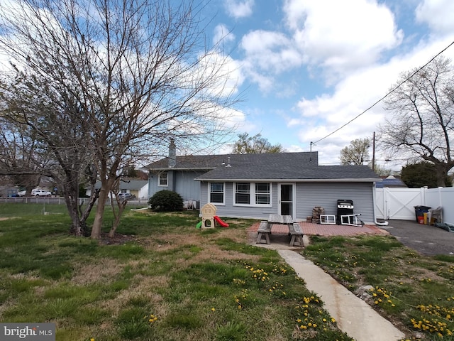 back of house featuring fence, a wooden deck, a gate, and a yard