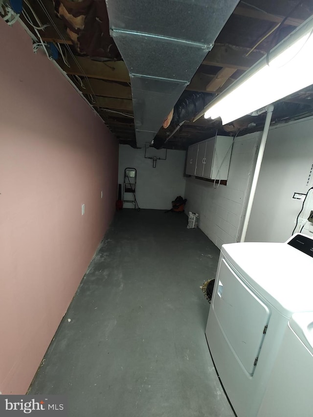 unfinished below grade area with washing machine and clothes dryer