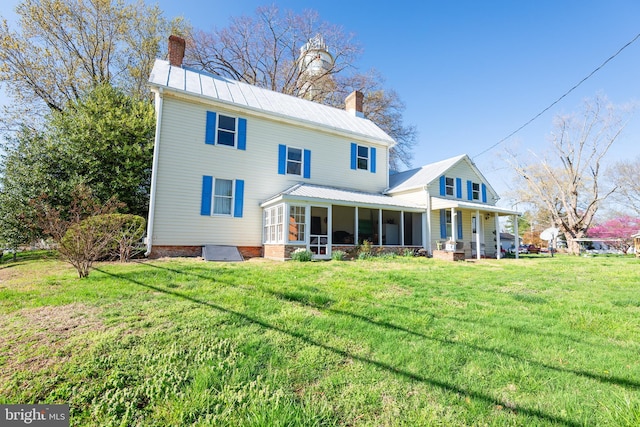 100 Wall St, Queenstown, MD 21658 - rear view of property with a lawn, a sunroom, metal roof, and a chimney