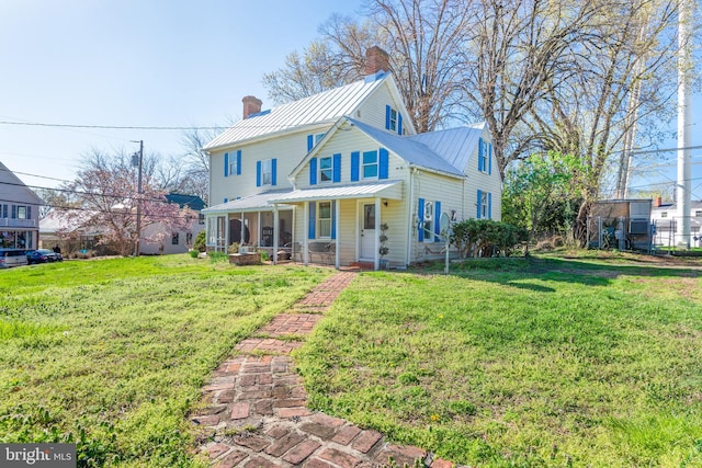 100 Wall St, Queenstown, MD 21658 - view of front facade with metal roof, a chimney, a front yard, a standing seam roof, and covered porch