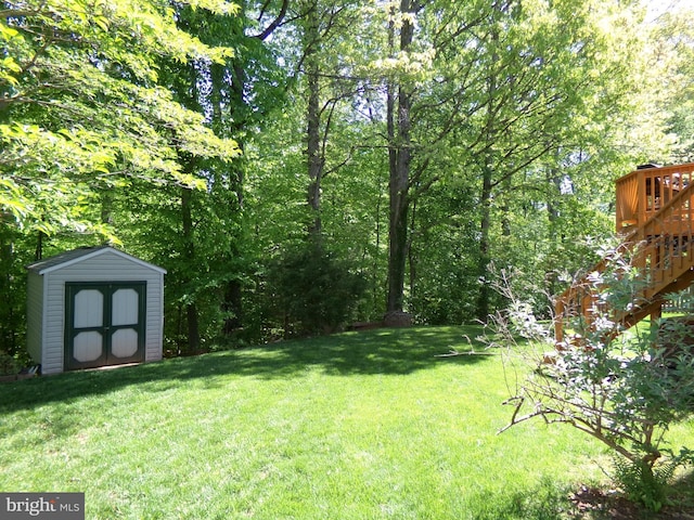 view of yard featuring stairs, an outbuilding, and a storage shed