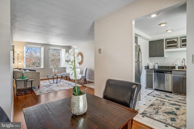 dining space featuring baseboards and light wood-style floors