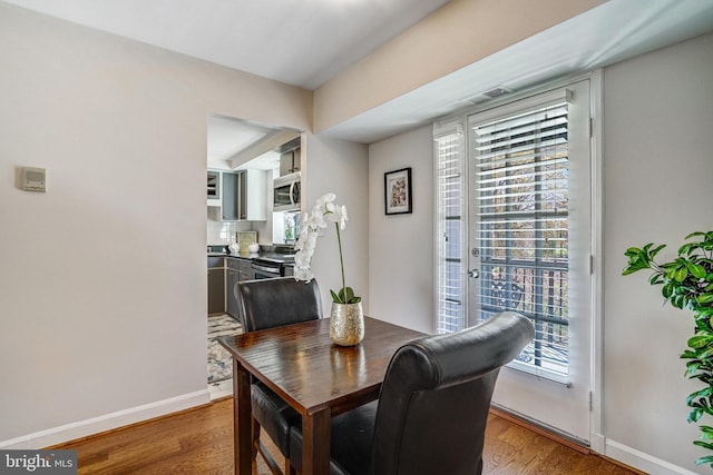 dining space featuring baseboards and wood finished floors