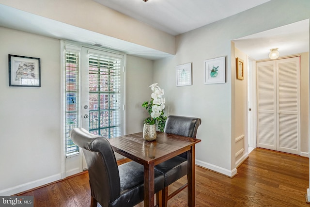 dining space with baseboards and wood finished floors